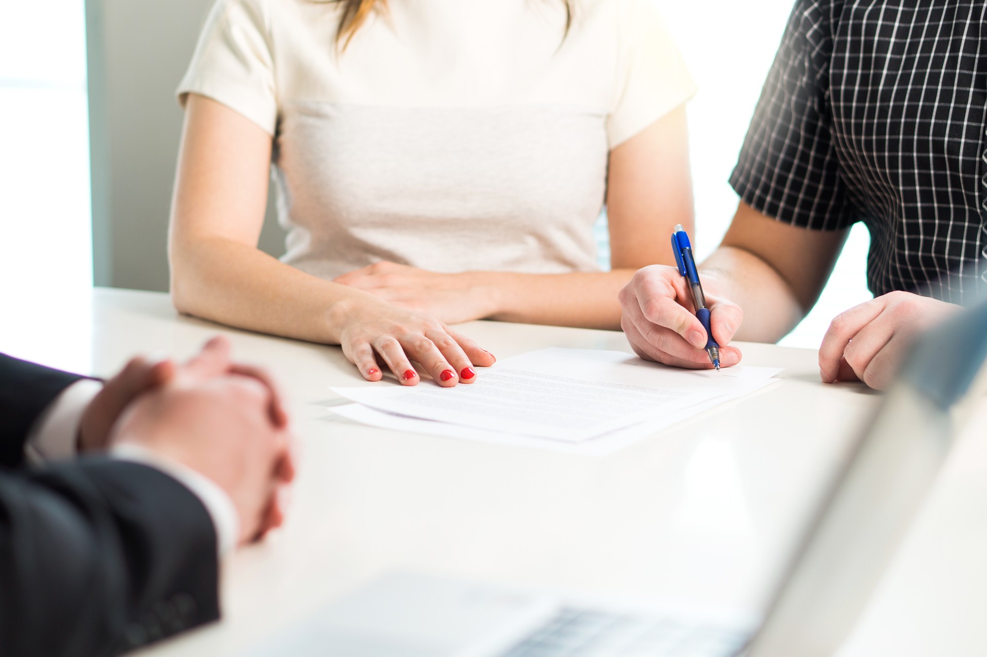 Happy young couple signing agreement or contract. Health insurance document, bank loan, mortgage or apartment rental paper.